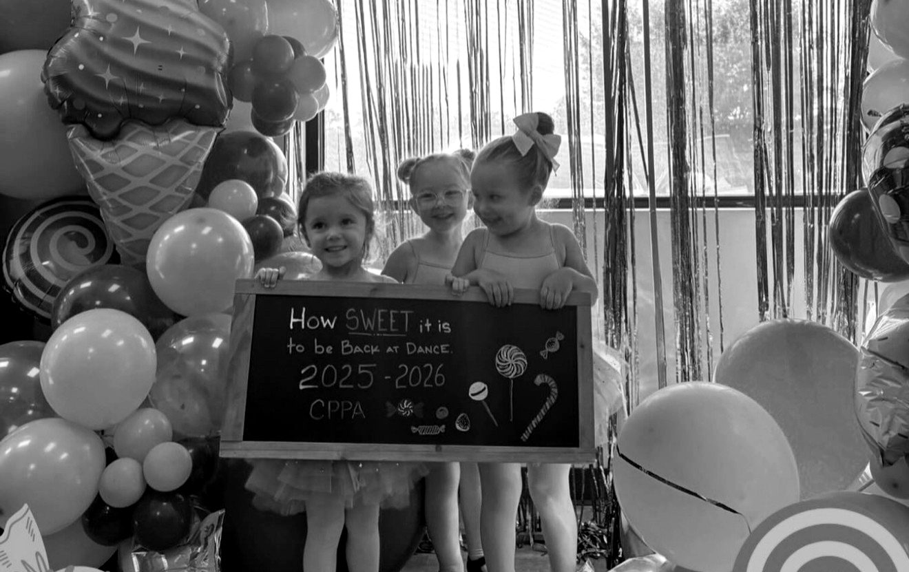 Young dancers holding a chalkboard that reads “How sweet it is to be back at dance, 2025–2026”