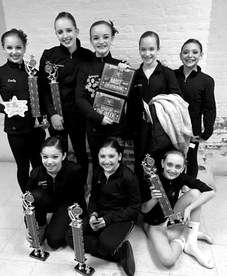Centre Pointe dancers in team jackets with their competition trophies