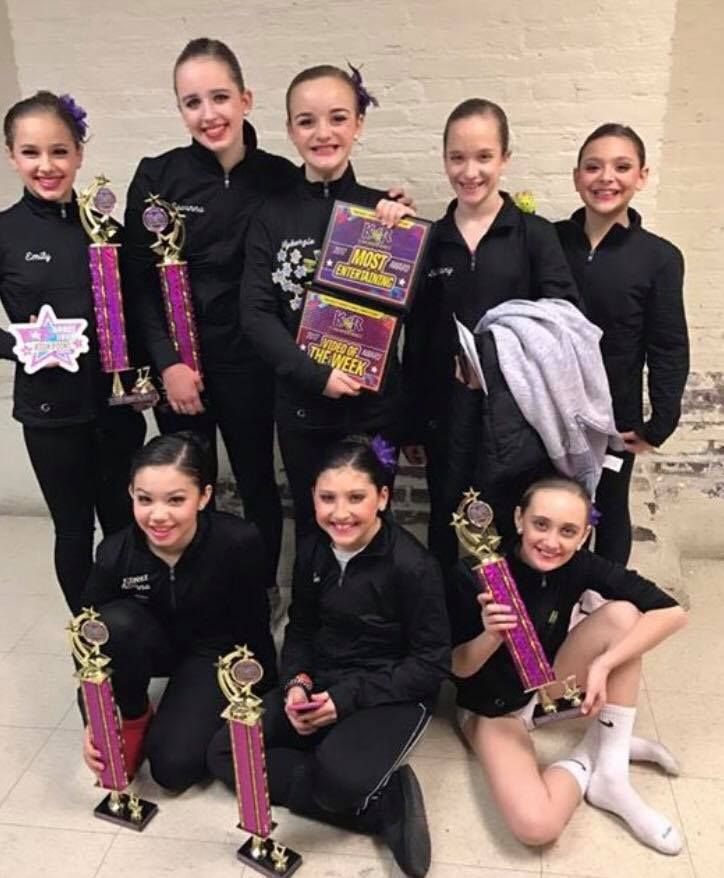 Centre Pointe dancers in team jackets with their competition trophies