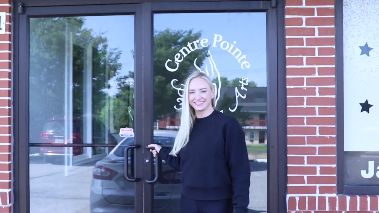 A Centre Pointe staff member waves from the studio's front door on Pulaski Highway, then walks into the lobby